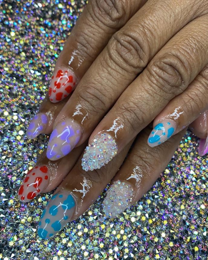 Hand-painted acrylic nail art on a holographic backdrop