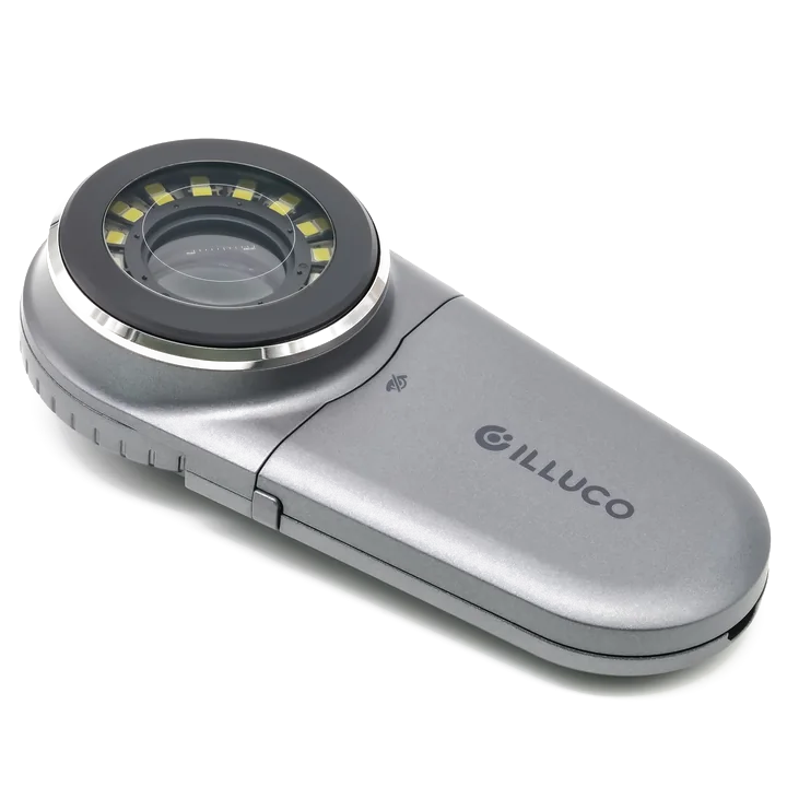 An Illuco IDS-1100 dermatoscope: a silver handheld body with a ring of LEDs around a lens at one end, shown against no background.