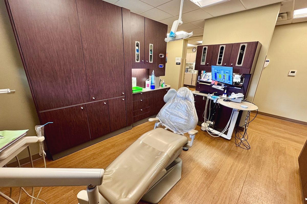 A bright dental treatment room with a chair and overhead light